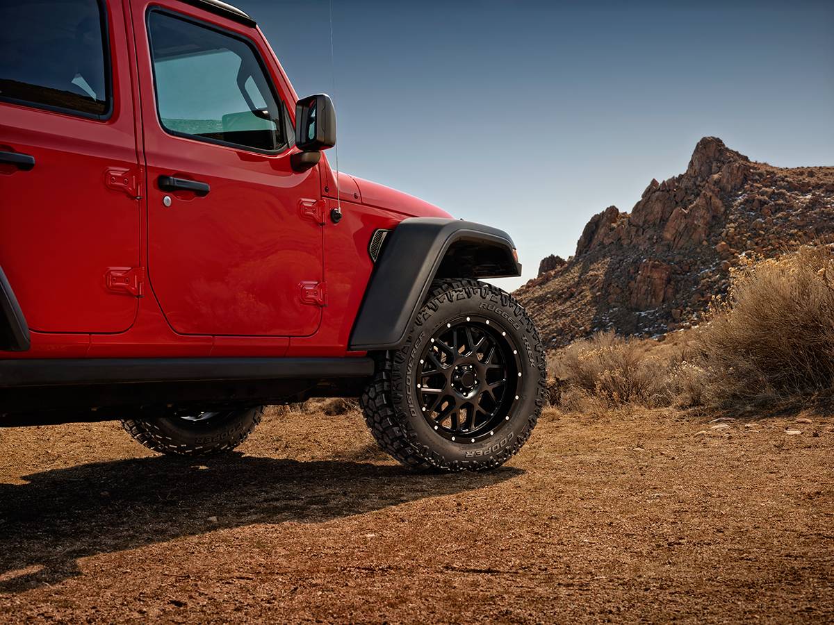 DISCOVERER RUGGED TREK 装着 — 赤いJeep Wrangler 砂漠のタイヤクローズアップ